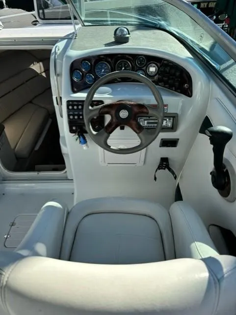 Slide: The Image of 2002 Crownline 215 CCR boat cockpit with steering wheel and dashboard controls. - 12