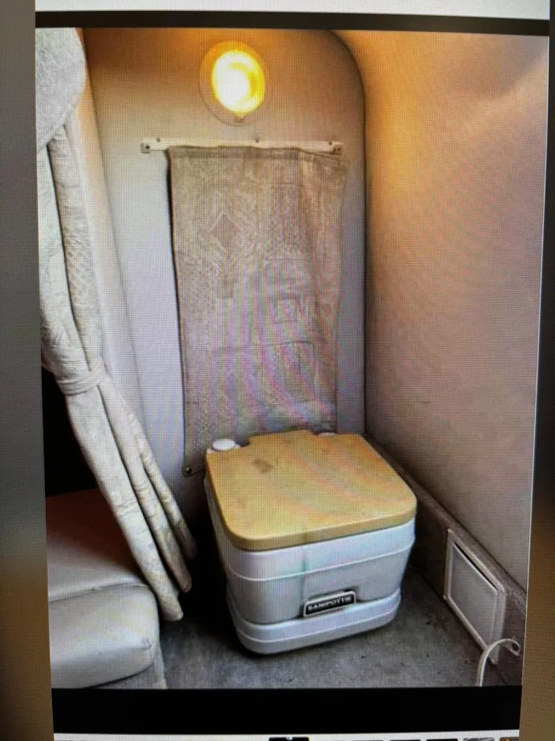 Slide: The Image of 2002 Crownline 215 CCR cabin interior with portable toilet and curtain. - 4