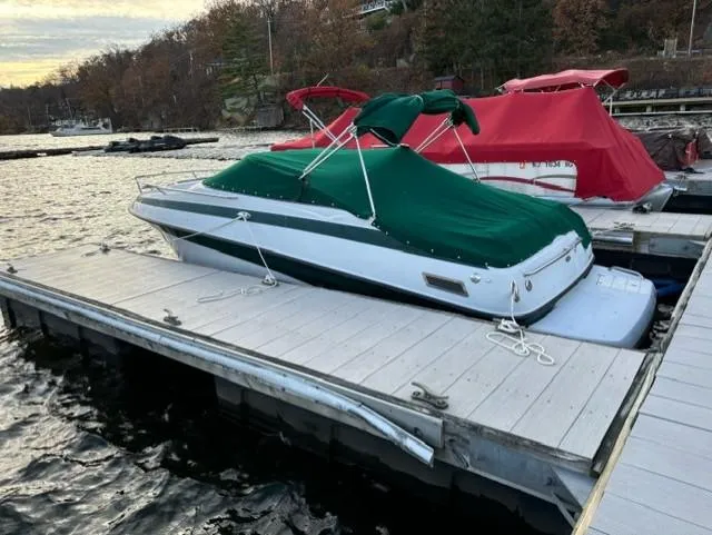 Slide: The Image of 2002 Crownline 215 CCR boat docked with green cover on a lake. - 7