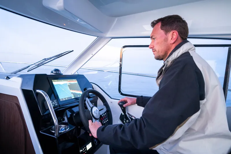 Slide: The Image of Man steering 2024 Beneteau Antares 8 Fishing boat, focused on navigation. - 4