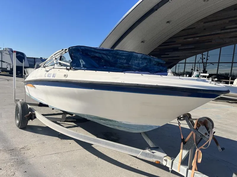 Slide: The Image of 2004 Bayliner 175 boat on trailer in front of modern building. - 7