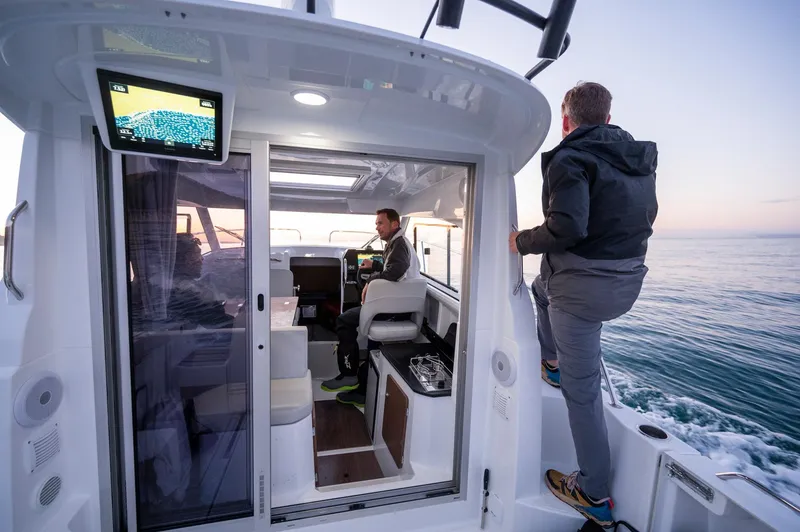 Slide: The Image of 2024 Beneteau Antares 8 Fishing boat on water, interior view with two people. - 9