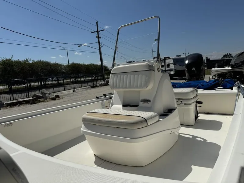 Slide: The Image of 2017 Mako Pro Skiff 19 CC boat with seating and console, parked outdoors. - 12