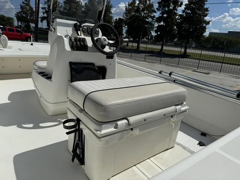 Slide: The Image of 2017 Mako Pro Skiff 19 CC boat interior with steering console and cushioned seating. - 16