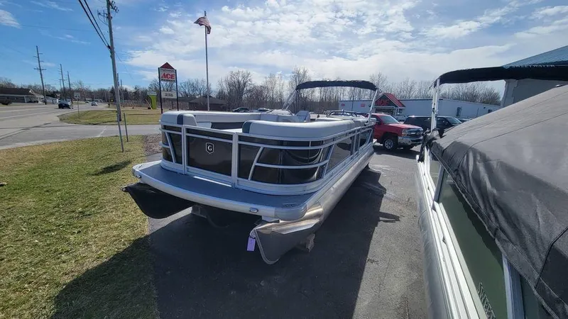 Slide: The Image of 2025 Godfrey Sweetwater 2486 C Sport Tube pontoon boat parked outdoors on a sunny day. - 5