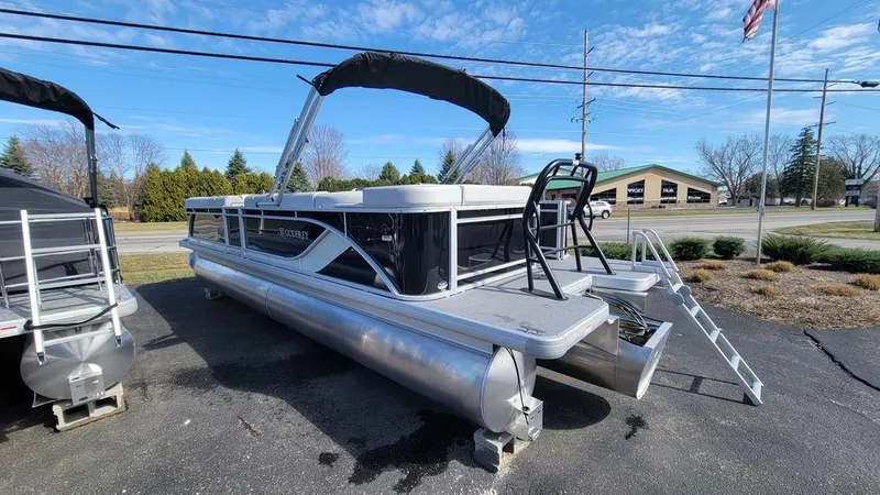 Slide: The Image of 2025 Godfrey Sweetwater 2486 C Sport Tube pontoon boat on display outdoors. - 6