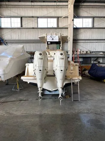 Slide: The Image of 2025 Scout 260 LXF boat with twin engines in a storage facility. - 2