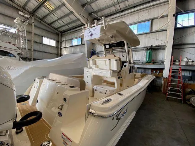 Slide: The Image of 2025 Scout 260 LXF boat in a warehouse, showcasing sleek design and modern features. - 4