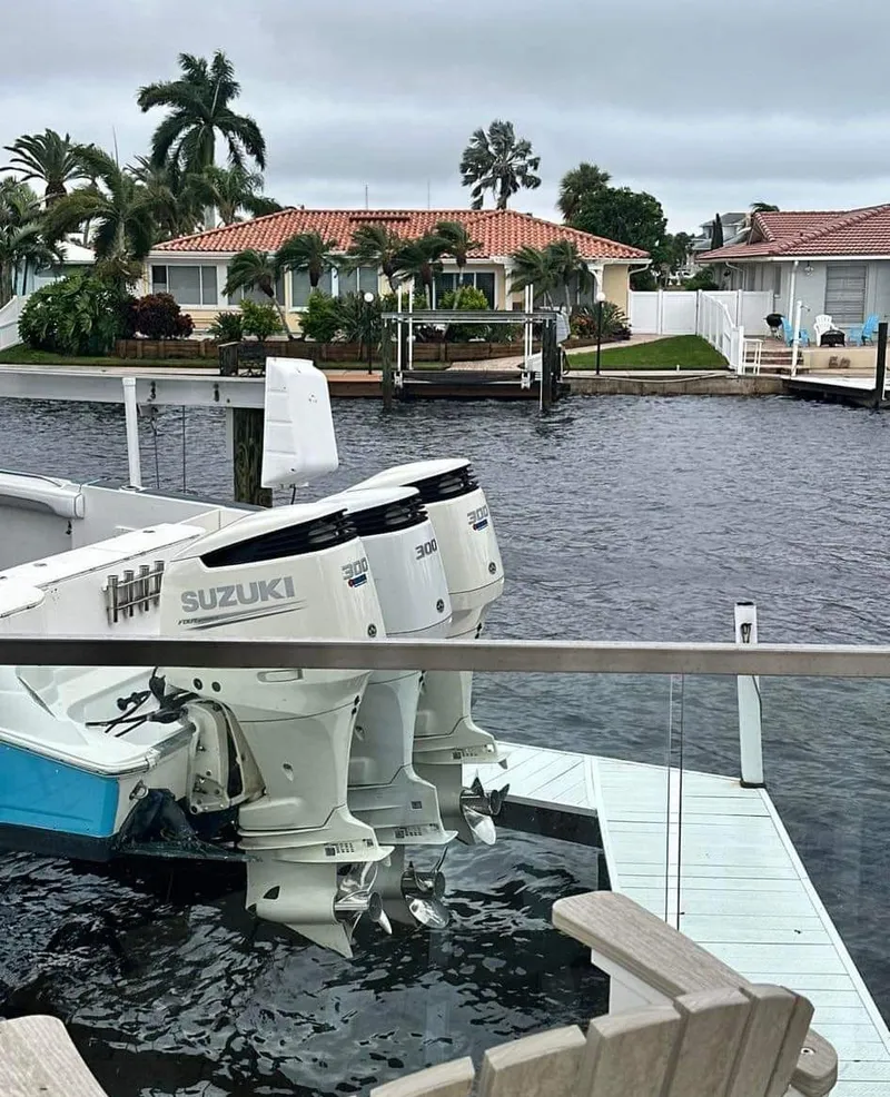 Slide: The Image of 2007 Scarab 35 Tournament boat with Suzuki engines docked by waterfront homes. - 12