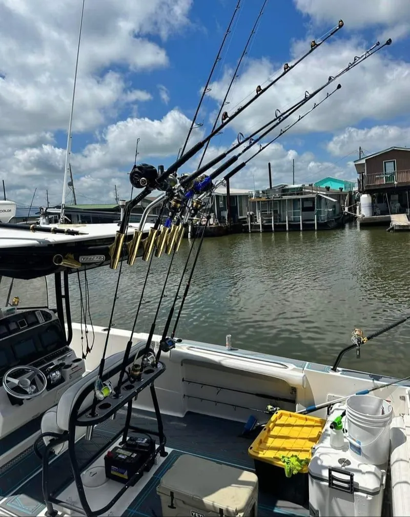 Slide: The Image of 2007 Scarab 35 Tournament boat with fishing rods, docked by a marina under a cloudy sky. - 7