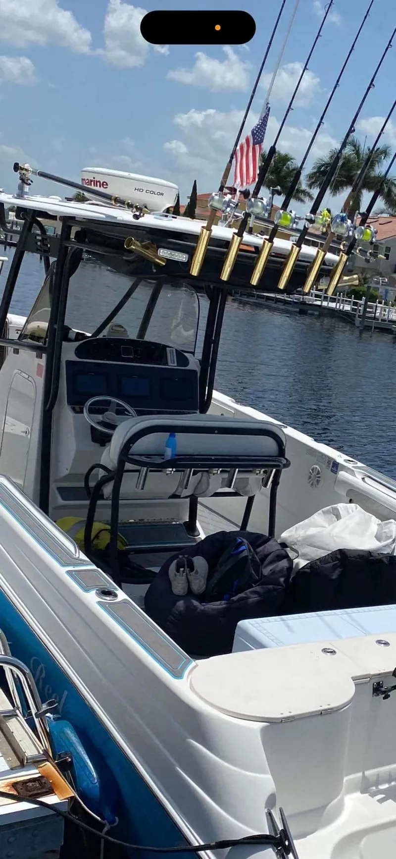 Slide: The Image of 2007 Scarab 35 Tournament boat with fishing rods, docked by a waterfront. - 9