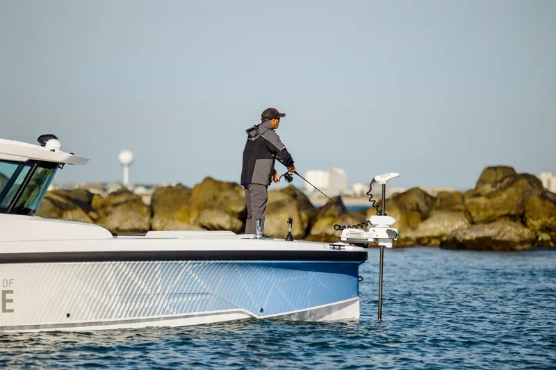 Slide: The Image of Person fishing on a 2025 Axopar 29 CCX boat near rocky shoreline. - 15