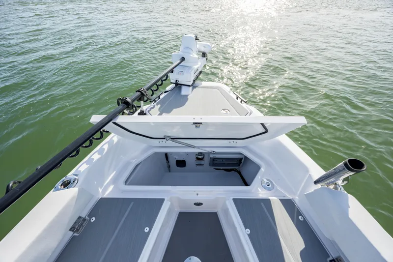 Slide: The Image of 2025 Axopar 29 CCX boat deck with open storage compartment on calm water. - 17