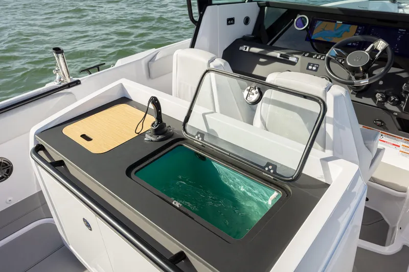 Slide: The Image of 2025 Axopar 29 CCX boat interior with open storage compartment and control panel. - 23