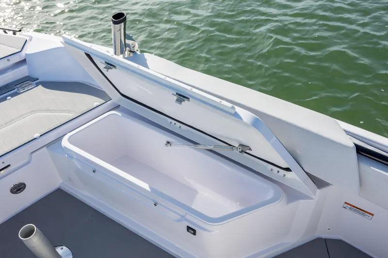 Slide: The Image of Open storage compartment on 2025 Axopar 29 CCX boat, near water. - 29