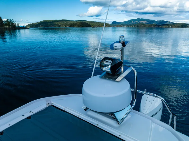 Slide: The Image of Axopar 28 boat on serene lake with scenic mountain backdrop, 2022 model. - 12