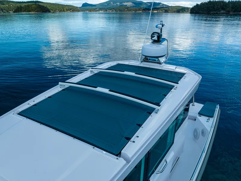 Slide: The Image of Axopar 28 boat, 2022 model, cruising on a serene lake with scenic mountain views. - 13