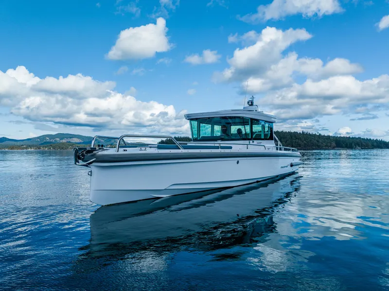 Slide: The Image of 2022 Axopar 28 boat cruising on a serene lake under a blue sky. - 17