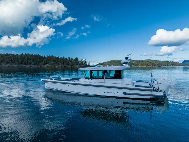 Slide: The Image of 2022 Axopar 28 boat on serene blue water under a clear sky. - 18