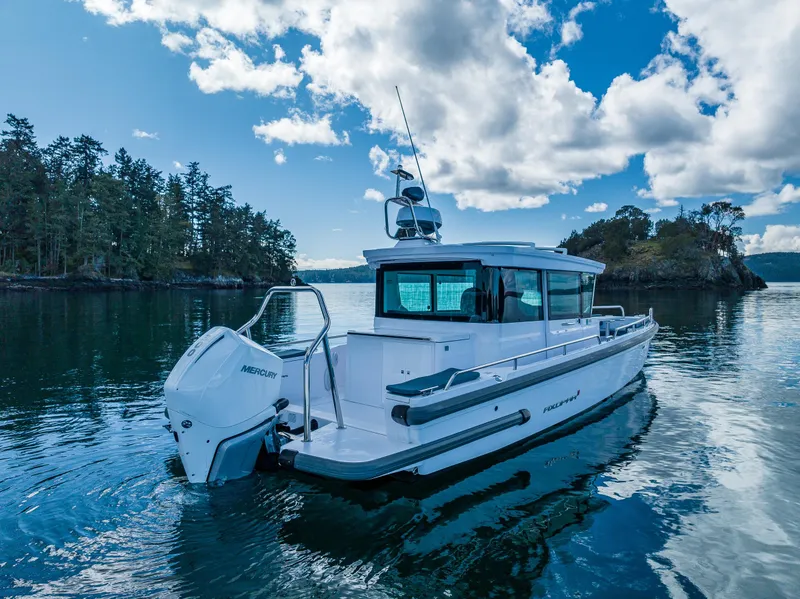 Slide: The Image of 2022 Axopar 28 boat on serene water with scenic forested background. - 20