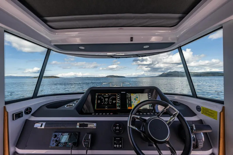 Slide: The Image of Interior view of 2022 Axopar 28 boat cockpit with navigation screens and steering wheel. - 31