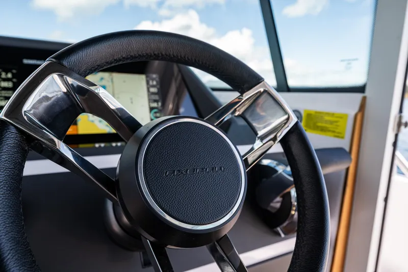 Slide: The Image of Steering wheel of 2022 Axopar 28 boat with navigation display in background. - 32