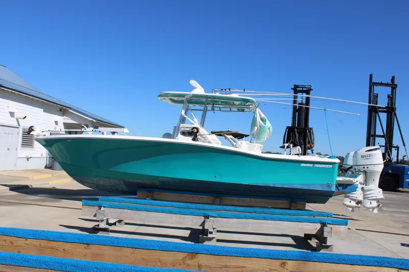 Slide: The Image of 2008 Jersey Cape 31 Little Devil boat on dock, vibrant blue hull, clear sky background. - 0