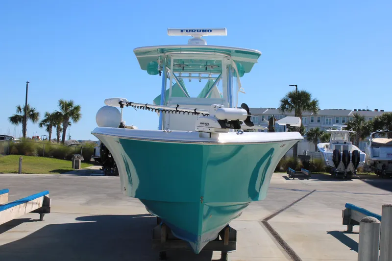 Slide: The Image of 2008 Jersey Cape 31 Little Devil boat on trailer, turquoise hull, marina background. - 3