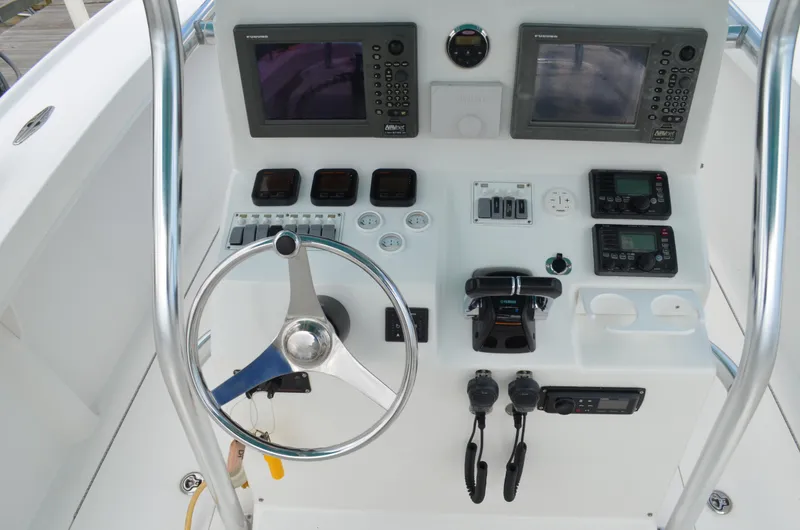 Slide: The Image of 2008 Jersey Cape 31 Little Devil boat dashboard with steering wheel and navigation controls. - 49