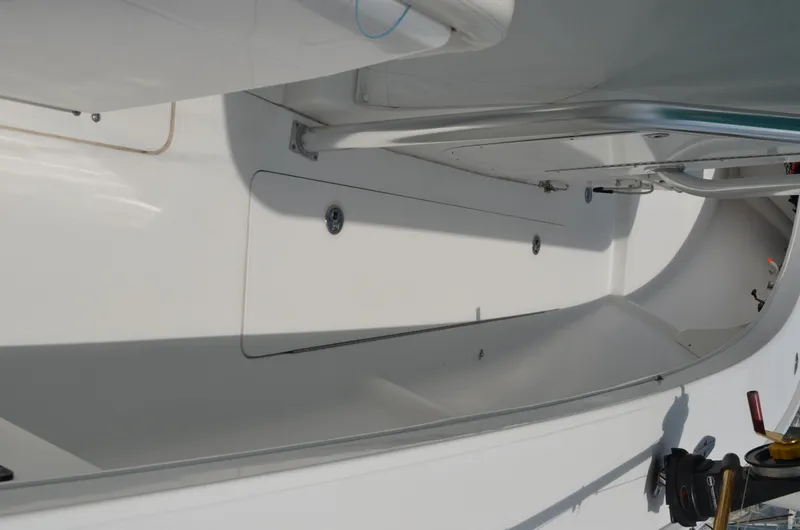 Slide: The Image of 2008 Jersey Cape 31 Little Devil boat interior, featuring sleek white design and storage compartments. - 5
