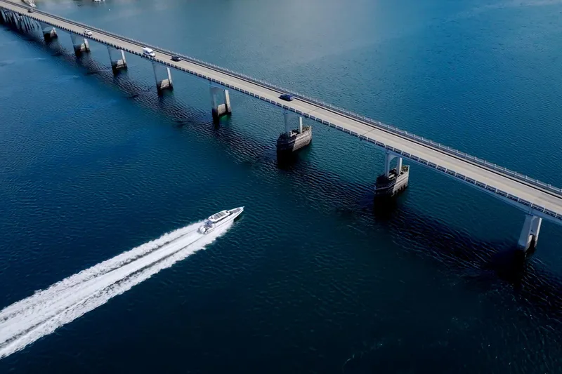 Slide: The Image of Axopar 37 XC boat speeding under bridge on open water, 2021 model. - 33
