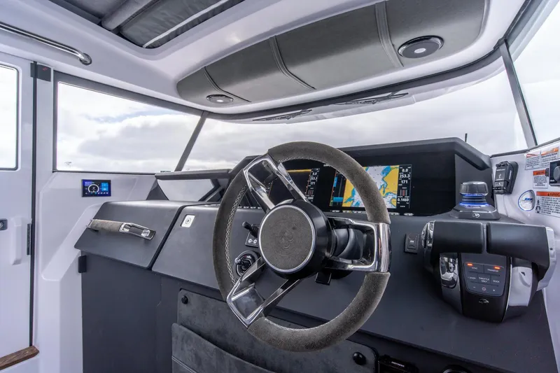 Slide: The Image of Interior of 2021 Axopar 37 XC boat, featuring modern steering and navigation controls. - 9