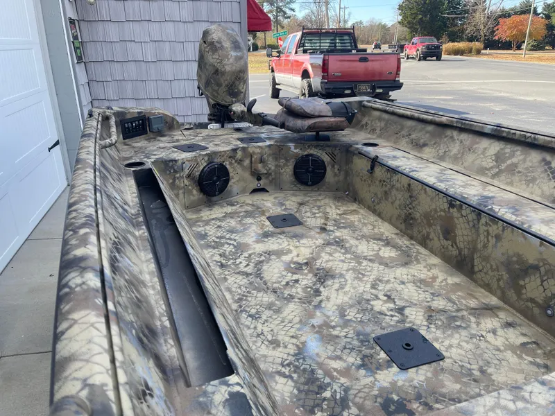 Slide: The Image of 2025 Excel 1751 River Warrior boat with camouflage design, parked outdoors. - 7