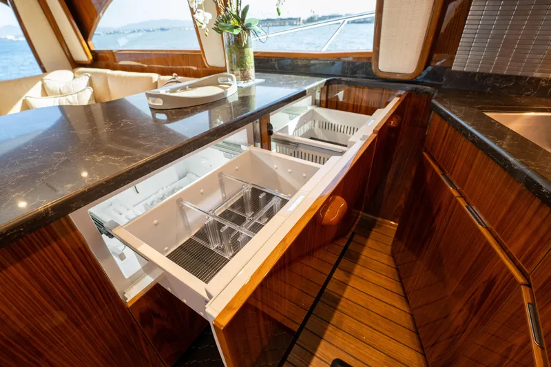 Slide: The Image of Luxurious interior of 2022 Viking 54 Convertible yacht with open drawer and elegant wood finish. - 16