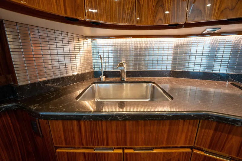 Slide: The Image of Luxurious kitchen sink area in 2022 Viking 54 Convertible yacht with wood cabinetry. - 18