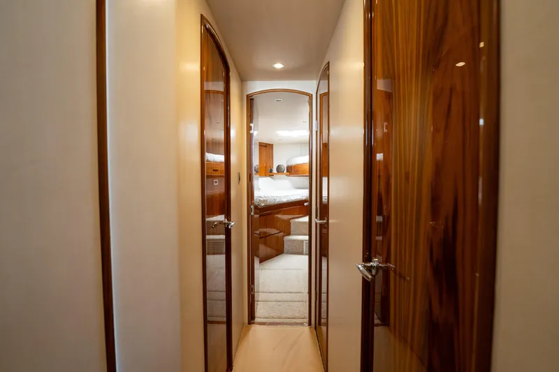 Slide: The Image of Interior hallway of 2022 Viking 54 Convertible yacht with wooden doors and cozy bedroom view. - 20