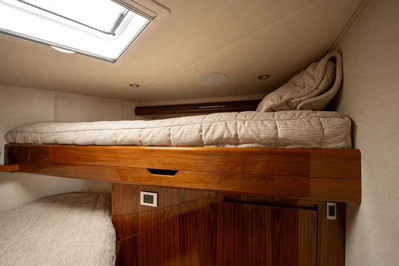 Slide: The Image of Interior of 2022 Viking 54 Convertible yacht with cozy bunk bed and wooden finish. - 22
