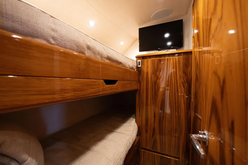 Slide: The Image of Luxurious cabin interior of 2022 Viking 54 Convertible yacht with wooden finish and bunk beds. - 25