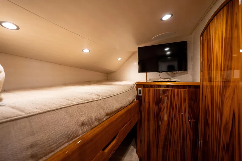 Slide: The Image of 2022 Viking 54 Convertible yacht interior with cozy bed and mounted TV. - 26