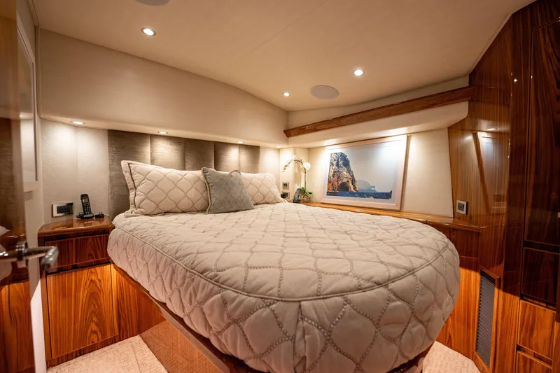Slide: The Image of Luxurious bedroom interior of 2022 Viking 54 Convertible yacht with elegant bedding and wood finishes. - 34