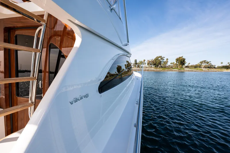 Slide: The Image of 2022 Viking 54 Convertible yacht on serene water, showcasing sleek design and craftsmanship. - 45