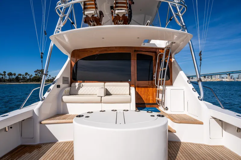 Slide: The Image of 2022 Viking 54 Convertible yacht, spacious deck with seating, ocean view, clear blue sky. - 49