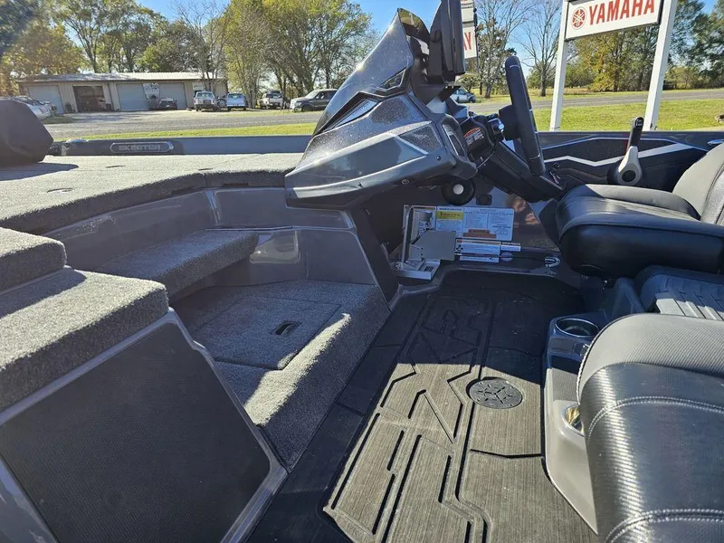 Slide: The Image of 2025 Skeeter FXR21L boat interior with steering console and seating. - 12