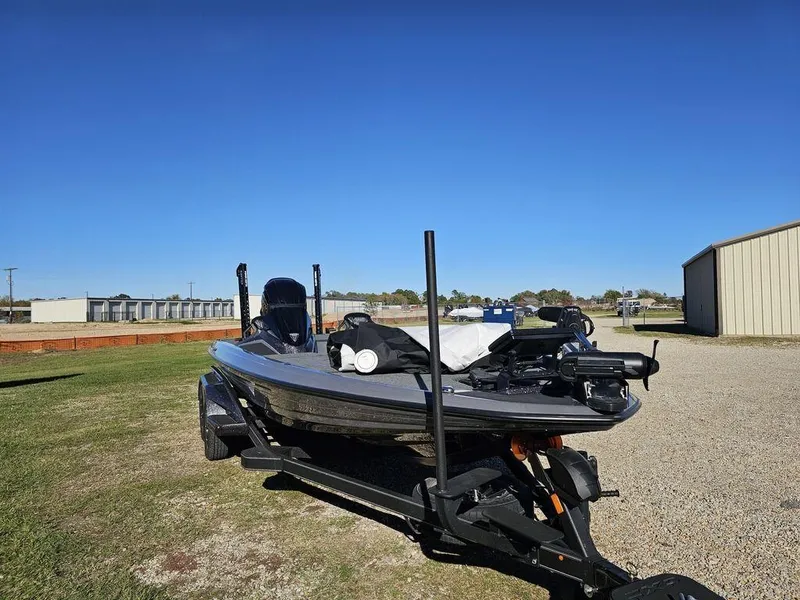 Slide: The Image of 2025 Skeeter FXR21L bass boat on trailer under clear blue sky. - 8