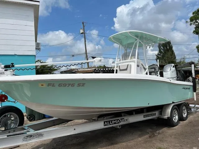 Slide: The Image of 2021 Aquasport 230 Pro Bay boat on trailer, light blue hull, parked outdoors. - 11