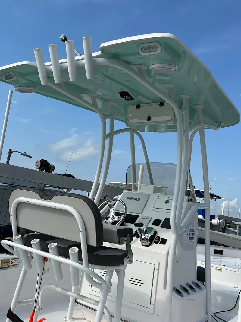 Slide: The Image of 2021 Aquasport 230 Pro Bay boat with T-top and console, docked under blue sky. - 3