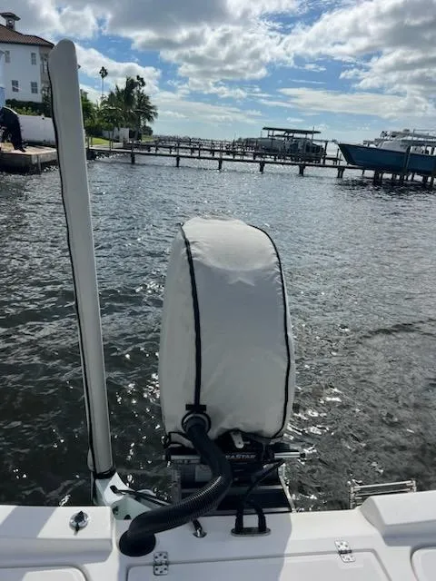 Slide: The Image of 2021 Aquasport 230 Pro Bay boat with covered motor, docked by a scenic waterfront. - 7