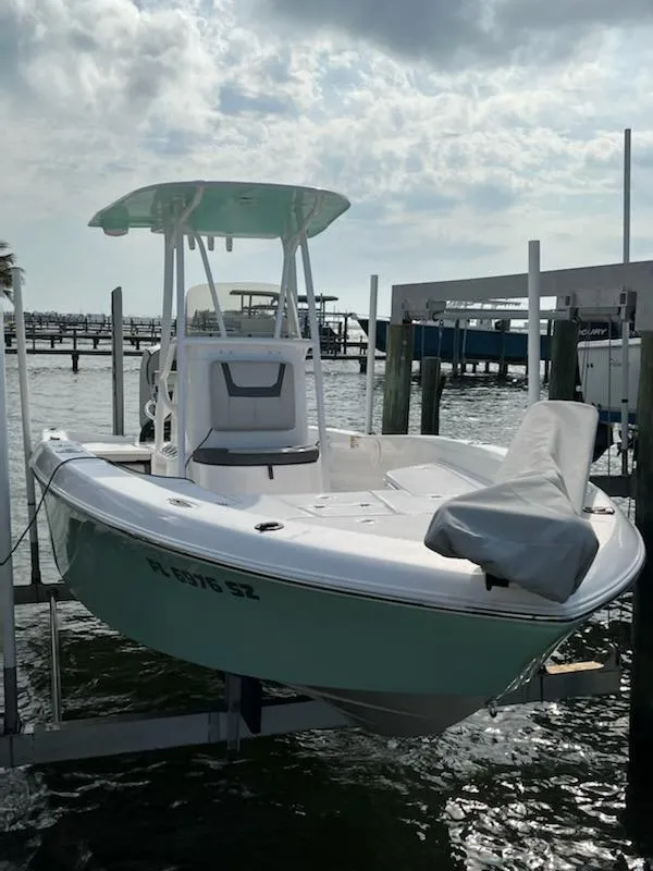 Slide: The Image of 2021 Aquasport 230 Pro Bay boat docked on lift, under cloudy sky. - 9