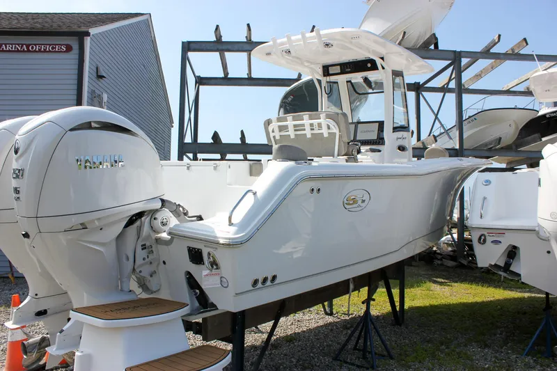 Slide: The Image of 2025 Sea Hunt Gamefish 27 Forward Seating boat, front view, in a marina setting. - 3