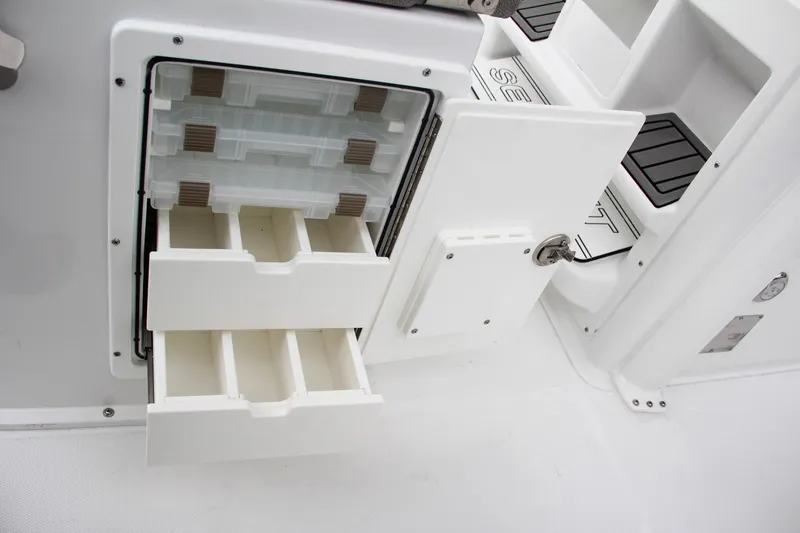 Slide: The Image of 2025 Sea Hunt Gamefish 27 storage compartment with open door and organized drawers. - 30